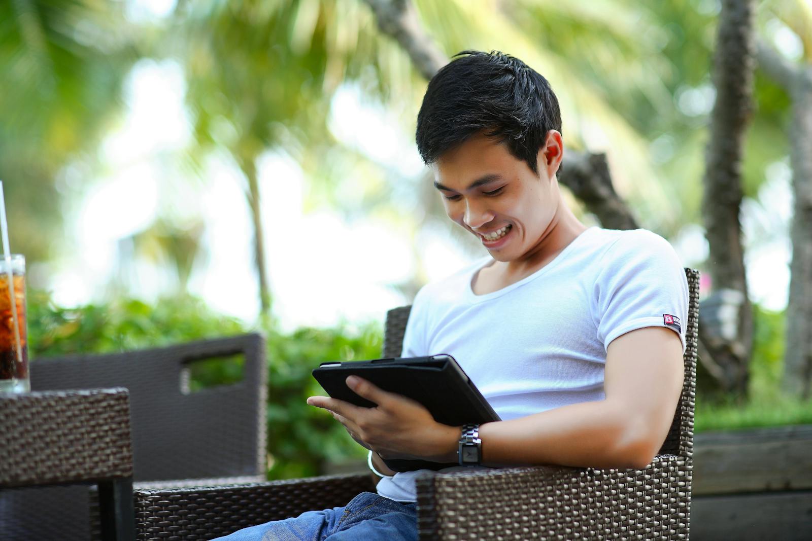 Man in White Shirt Using Tablet Computer Shallow Focus Photography